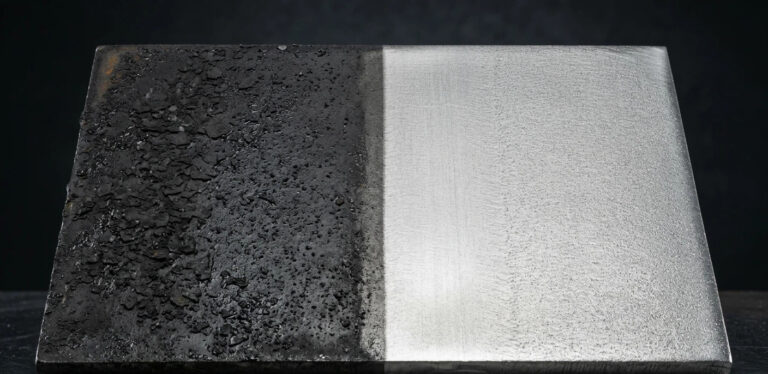 Side-by-side comparison of an industrial metal plate: left side shows heavy mill scale and lubricant contamination; right side shows clean metallic surface after Laser Surface Prep for improved welding and bonding.